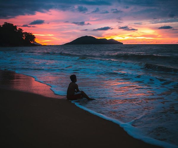 Silhouette of a person meditating during a beautiful sunset.