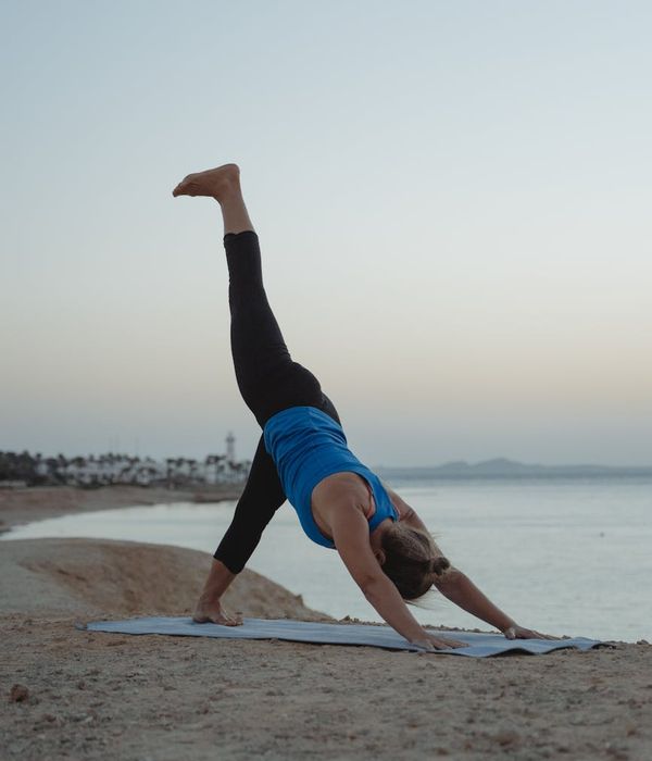 Woman in a calm yoga pose against an indigo background.